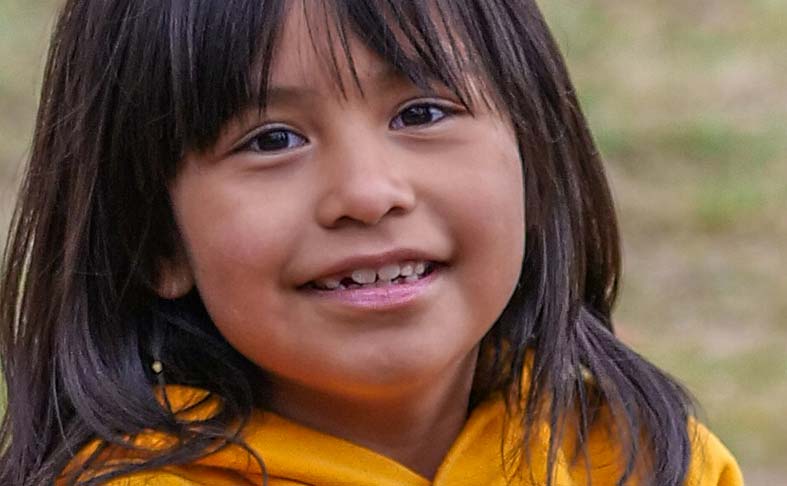 A young Alaska Native girl smiles for the camera