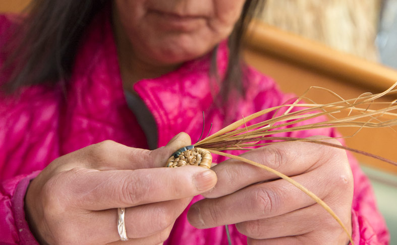 Elder starting her weave for a basket
